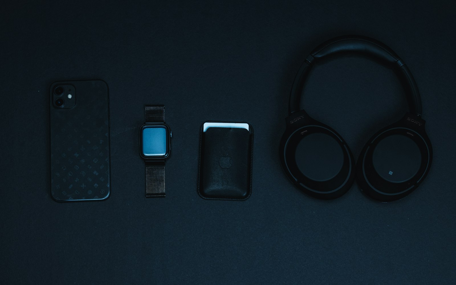 Televisore OLED, cuffie over-ear e smartphone in composizione su superficie neutra
